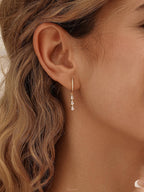 Exquisite diamond hoop earrings featuring tassels and crystal pendants; crafted from 18K gold and 925 sterling silver
