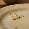 Gold flower-motif hoop earrings, delicate clip-style drop earrings