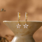 Gold flower-motif hoop earrings, delicate clip-style drop earrings