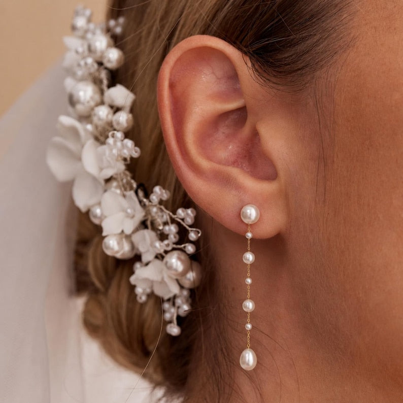 Long gold-tone drop earrings featuring natural freshwater pearls; minimalist-style 18K gold-plated earrings